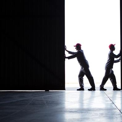 two workers opening up warehouse door
