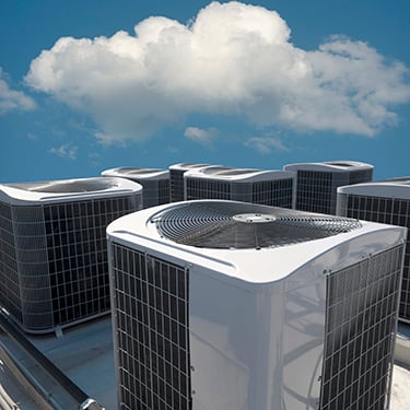 Rooftop AC units under clouds