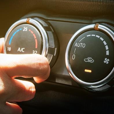 hand adjusting air conditioning and heating temperature on car console