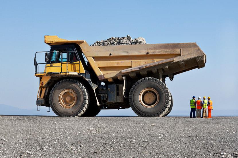 large dump truck next to people