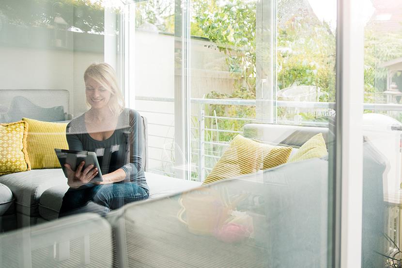 smiling woman using tablet on couch